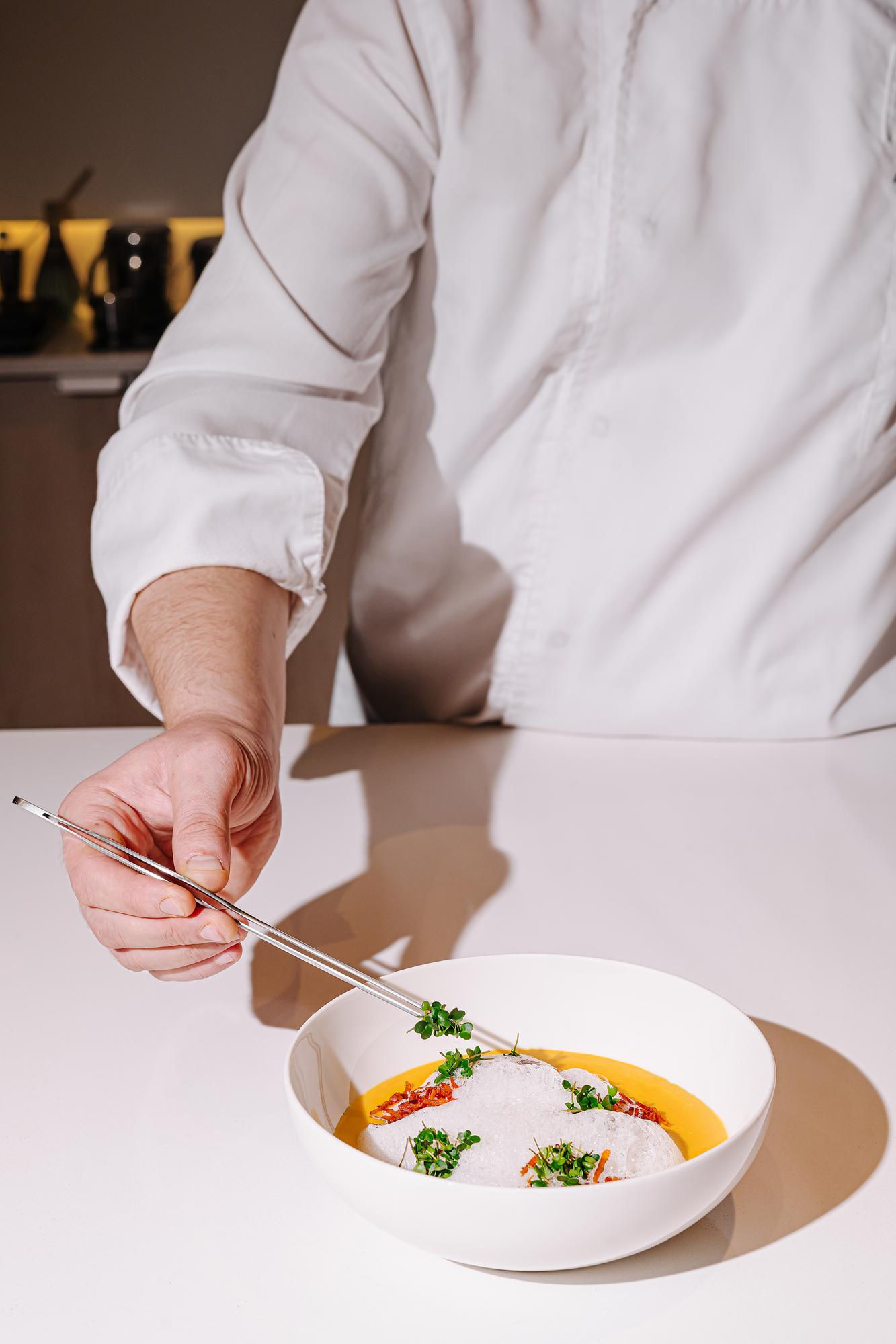 Chef arranging plate in minimal kitchen
