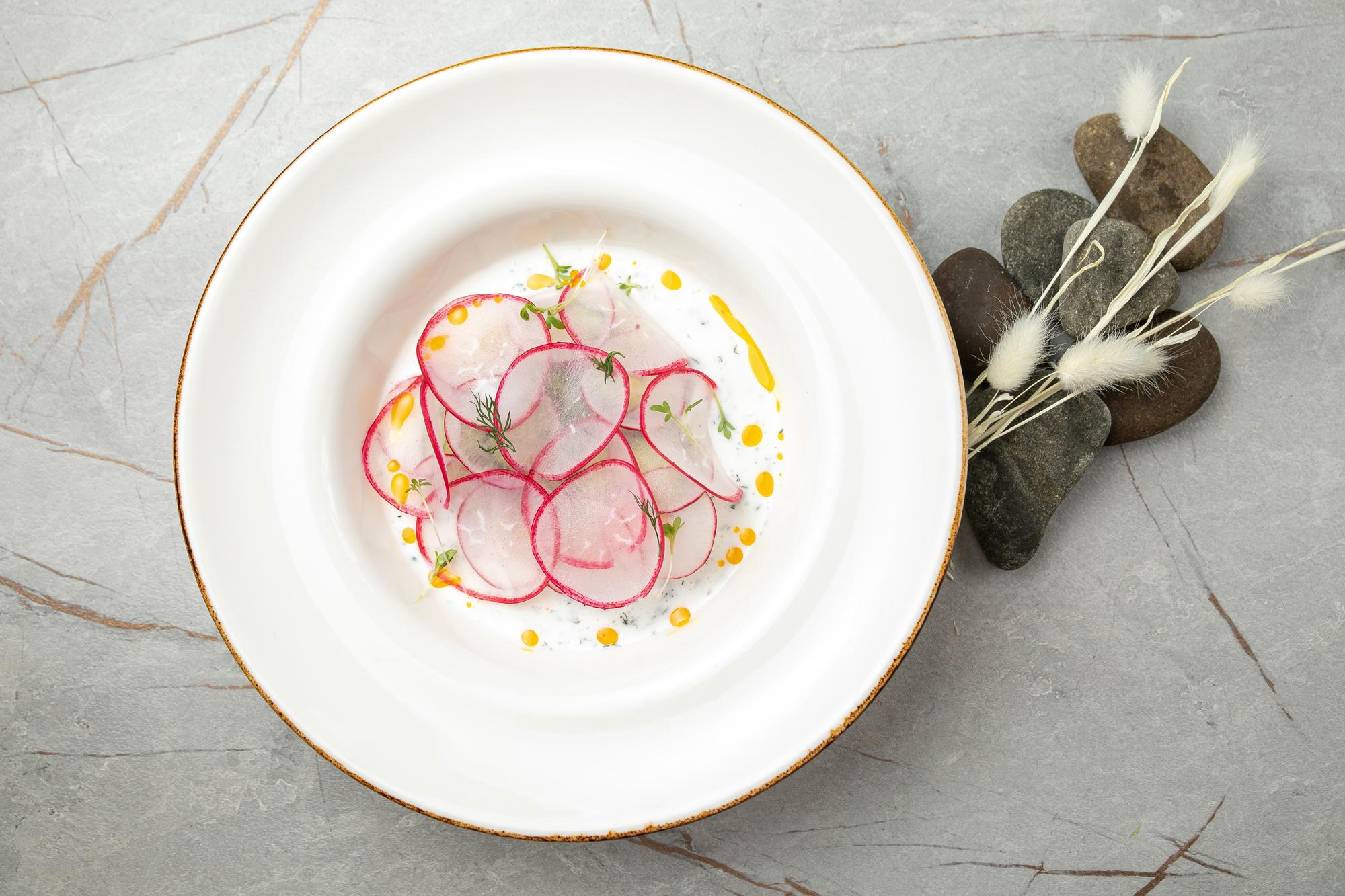 Gourmet meal on ceramic plate with cutlery
